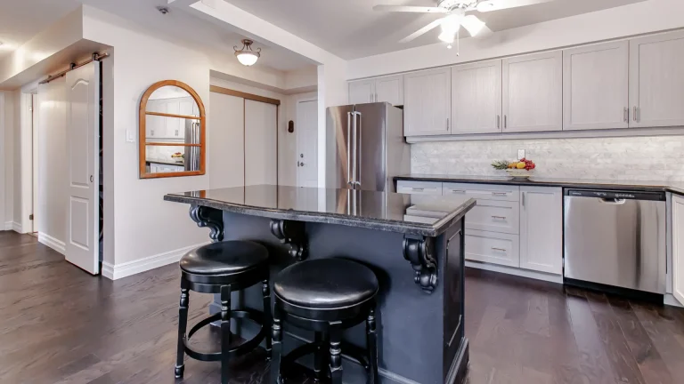 As expert kitchen refacers in Burlington, we transformed this Lakefront condo with Skye Gray shaker cabinets and a Tricorn Black super matte custom island.