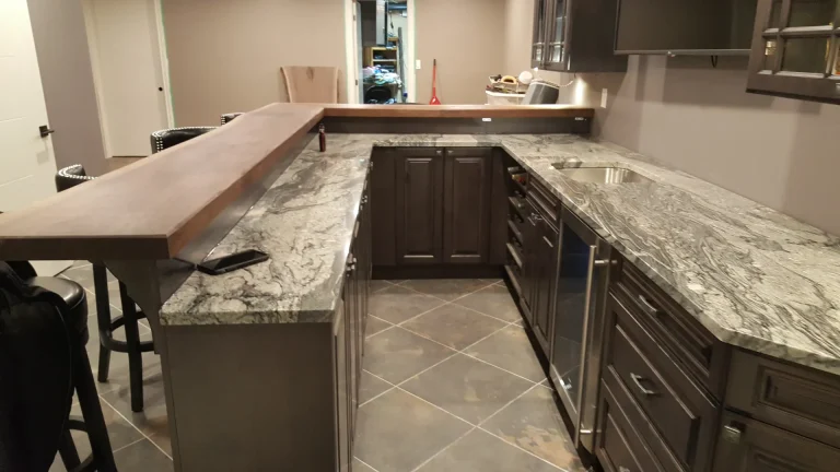 Dark custom cabinetry and a Winter Granite bar in a Milton man cave.