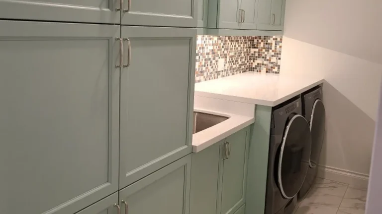 Professional laundry room cabinetry respraying in Burlington featuring vibrant green cabinets, an elevated folding table, and matching LG appliances.
