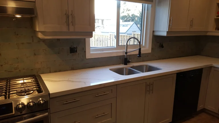 Light gray Skye five-piece cabinet doors with veined marble quartz and turquoise subway tile.